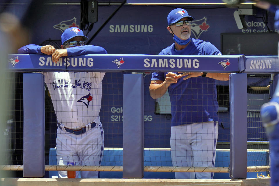 Toronto Blue Jays bench coach Dave Hudgens, right, yells at home plate umpire Junior Valentine after he was ejected during the first inning of a baseball game against the Tampa Bay Rays Monday, May 24, 2021, in Dunedin, Fla. Looking on is manager Charlie Montoyo. (AP Photo/Chris O'Meara)