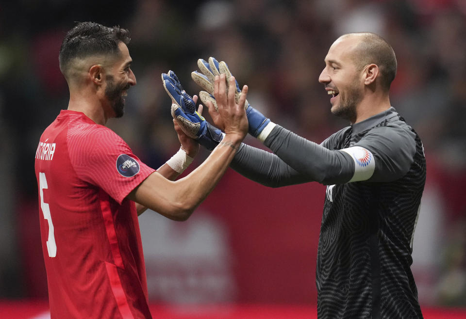 Canada's Steven Vitoria, left, and goalkeeper Milan Borjan celebrate after Canada defeated Curacao in a CONCACAF Nations League soccer match Thursday, June 9. 2022, in Vancouver, British Columbia. (Darryl Dyck/The Canadian Press via AP)
