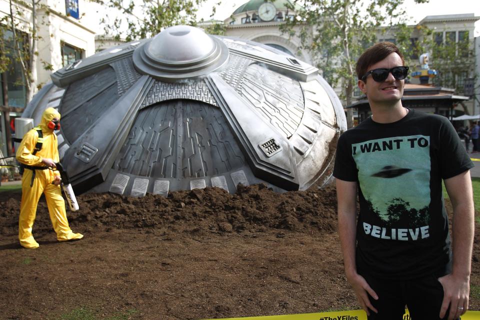 Fan trägt "I want to believe" UFO-T-Shirt vor FOX's "The X-Files" UFO-Episode Event mit UFO-Modell. - Copyright: Tommaso Boddi / Getty Images