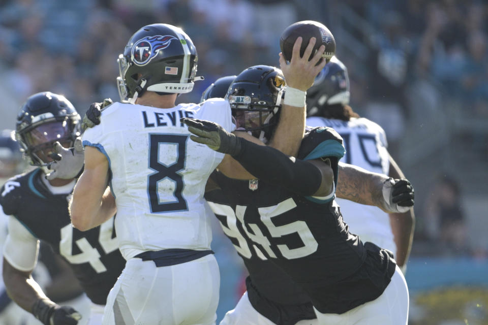 Tennessee Titans quarterback Will Levis (8) is hit by Jacksonville Jaguars linebacker K'Lavon Chaisson (45) as he throws a pass during the second half of an NFL football game, Sunday, Nov. 19, 2023, in Jacksonville, Fla. (AP Photo/Phelan M. Ebenhack)