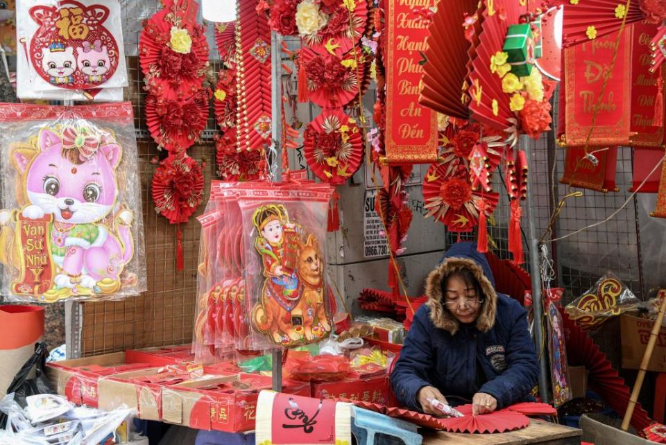 A shopkeeper at a stall that is selling cat images ahead of the Lunar New Year at a market in the old quarters of Hanoi, Jan. 17, 2023. As China gears up to welcome the Year of the Rabbit, celebrations are slightly different in Vietnam, where the Year of the Cat is about to begin.<span class="copyright">Nhac Nguyen—AFP via Getty Images</span>