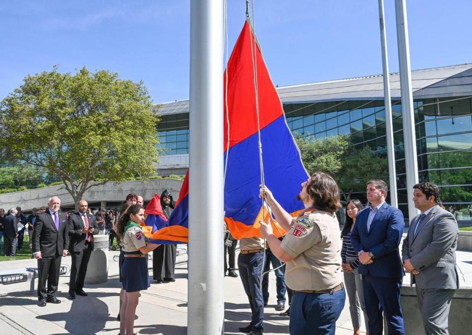 Fresno city and county officials gather around the city’s flag poles as Homenetmen Fresno Sassoon Chapter scouts raise the Armenian flag over Fresno City Hall during the annual Armenian Flag Raising Ceremony to commemorate the start of the Armenian Genocide 108 years ago, on Monday, April 24, 2023.