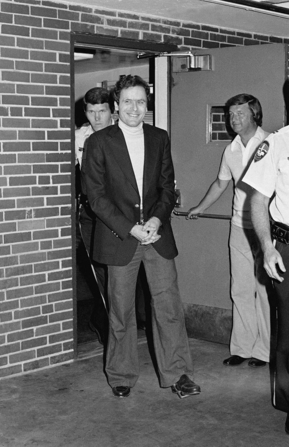 FILE - In this June 13, 1977 file photo, Ted Bundy appears in cuffs after being recaptured just outside of Aspen City limits. He was pulled over by the sheriff's department for driving erratically. The officers did not know it was him until they approached the car. He offered no resistance. (AP Photo)