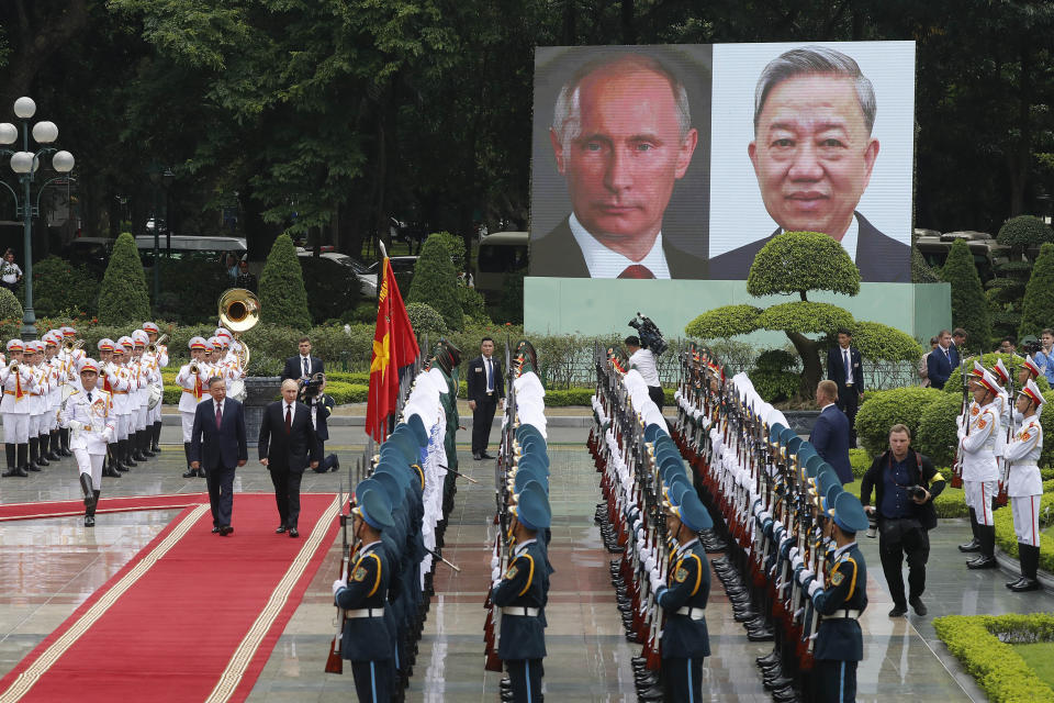 Vietnamese President To Lam, left on red carpet, and his Russian counterpart Vladimir Putin, right on red carpet, review the guard of honor at the Presidential Palace in Hanoi, Vietnam, Thursday, June 20, 2024. (AP Photo/Minh Hoang)