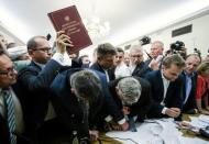 Michal Szczerba of Civic Platform (PO) party holds up a copy of the Polish Constituion as members of the parliament scuffle during the parliamentary Comission on Justice and Human Rights voting on the opposition's amendments to the bill that calls for an overhaul of the Supreme Court in Warsaw, Poland, July 20, 2017. Agencja Gazeta/Adam Stepien/via REUTERS