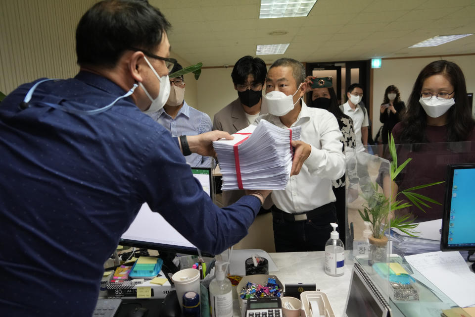 Peter Møller, center, attorney and co-founder of the Danish Korean Rights Group, submits the documents at the Truth and Reconciliation Commission in Seoul, South Korea, Tuesday, Sept. 13, 2022. Nearly 300 South Koreans who were adopted to European and American parents as children have so far filed applications demanding South Korea’s government to investigate their adoptions, which they suspect were based on falsified documents that laundered their real status or identities as agencies raced to export children. (AP Photo/Ahn Young-joon)