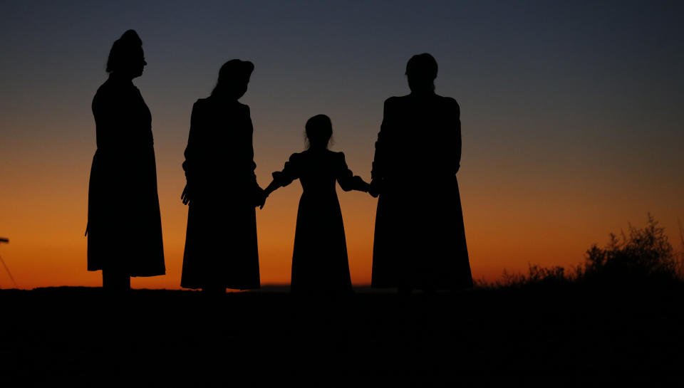 FILE - In this Oct. 25, 2017, file photo, women, who are members of a community on the Utah-Arizona border that has been home for more than a century to a polygamous sect that is an offshoot of mainstream Mormonism, gather for a photograph, in Colorado City, Ariz. The recent slaying in Mexico of nine people who belonged to a Mormon offshoot community where some people practice polygamy shines a new spotlight on the ongoing struggle for the mainstream church to fight the association with plural marriage groups because of its past. (AP Photo/Rick Bowmer, File)