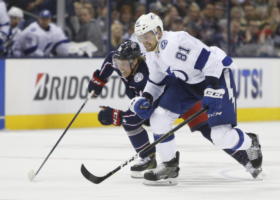 Columbus Blue Jackets' Ryan Dzingel, left, and Tampa Bay Lightning's Erik Cernak, of Slovakia, chase a loose puck during the second period of Game 3 of an NHL hockey first-round playoff series Sunday, April 14, 2019, in Columbus, Ohio. (AP Photo/Jay LaPrete)