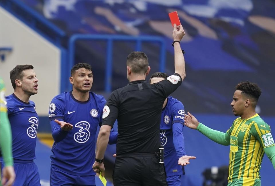 El árbitro David Coote muestra la tarjeta roja al brasileño Thiago Silva, del Chelsea, durante el partido de Chelsea contra West Bromwich Albion en el estadio Stamford Bridge en Londres, Inglaterra, sábado 3 de abril de 2021. West Brom, que está al borde del descenso, venció a Chelsea 5-2. (John Walton/Pool via AP)