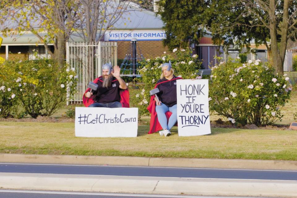 Tourism officials on the side of the road with signs.