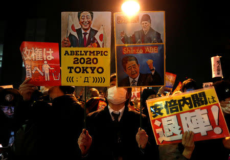 Protesters shout slogans and hold placards during a rally denouncing Japanese Prime Minister Shinzo Abe and Finance Minister Taro Aso over a suspected cover-up of a cronyism scandal in front of Abe's official residence in Tokyo, Japan March 14, 2018. REUTERS/Issei Kato