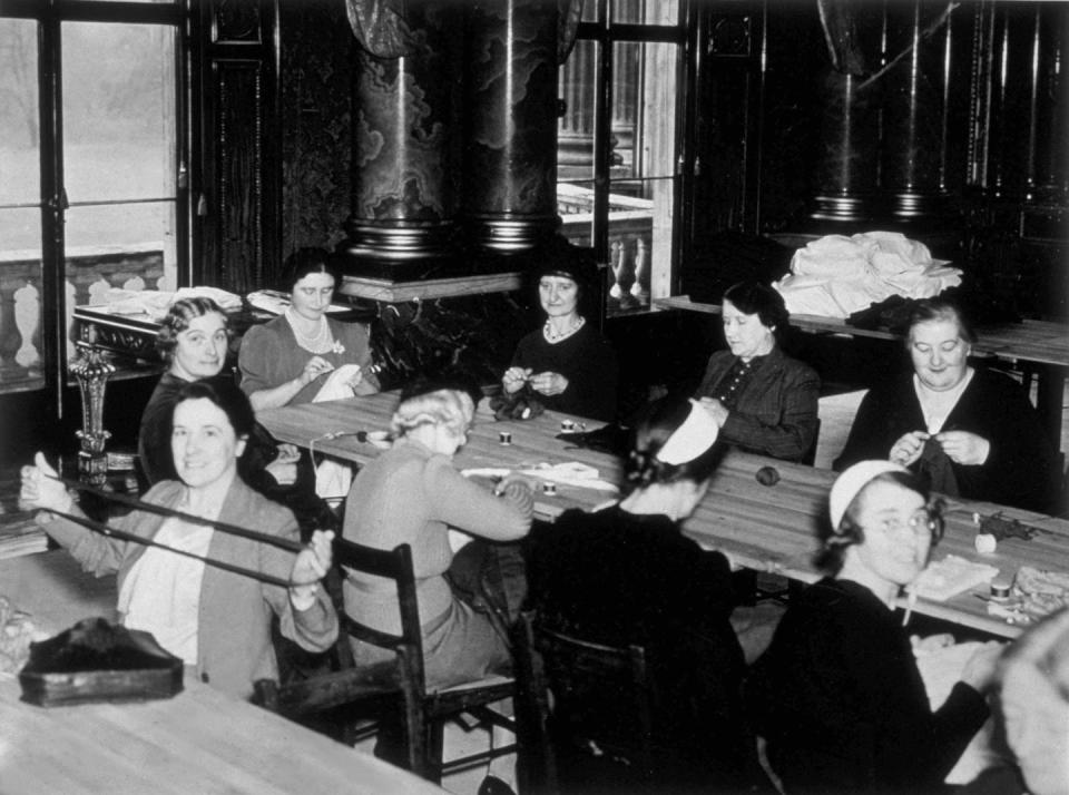 <p>The queen consort (Queen Elizabeth's mother) along with palace staff and their wives, gather for a meeting in the Blue Drawing Room one month after the start of World War II. They crafted clothes and surgical dressings for the Red Cross.</p>