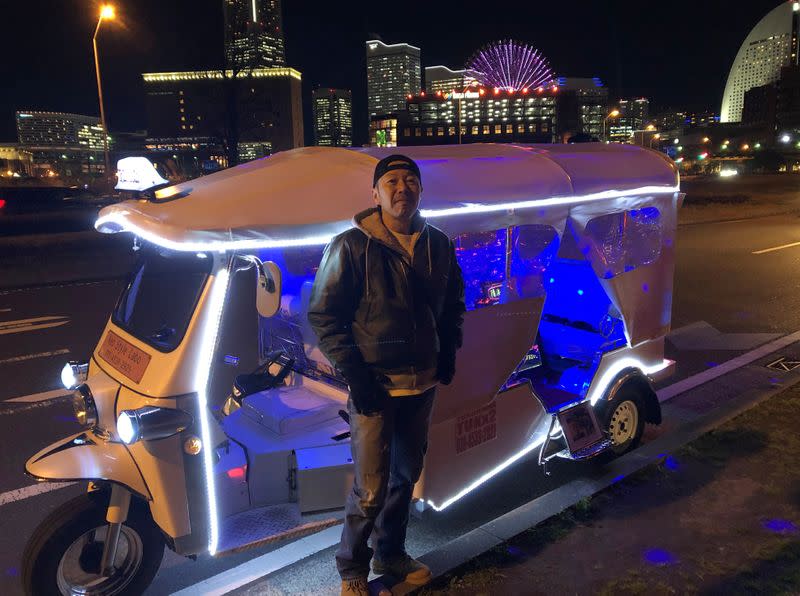 48-year-old Yoshio Adachi stands in front of his tuk tuk while waiting for customers to drive around Yokohama in Yokohama