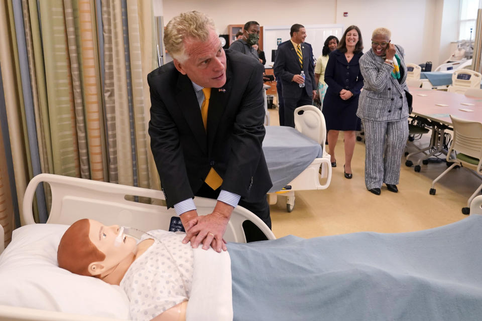 FILE - In this July 15, 2021, file photo, Democratic gubernatorial candidate Terry McAuliffe practices his CPR technique during a tour of a nursing training facility at Norfolk State University in Norfolk, Va. McAuliffe won Virginia's 2013 governor's race by embracing his own brand of personal politics that rely on decades-old friendships, back-slapping charisma and tell-it-like-it-is authenticity. (AP Photo/Steve Helber, File)