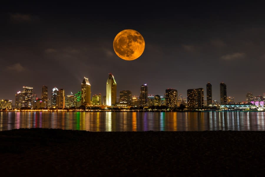 A full moon is pictured over the San Diego skyline.