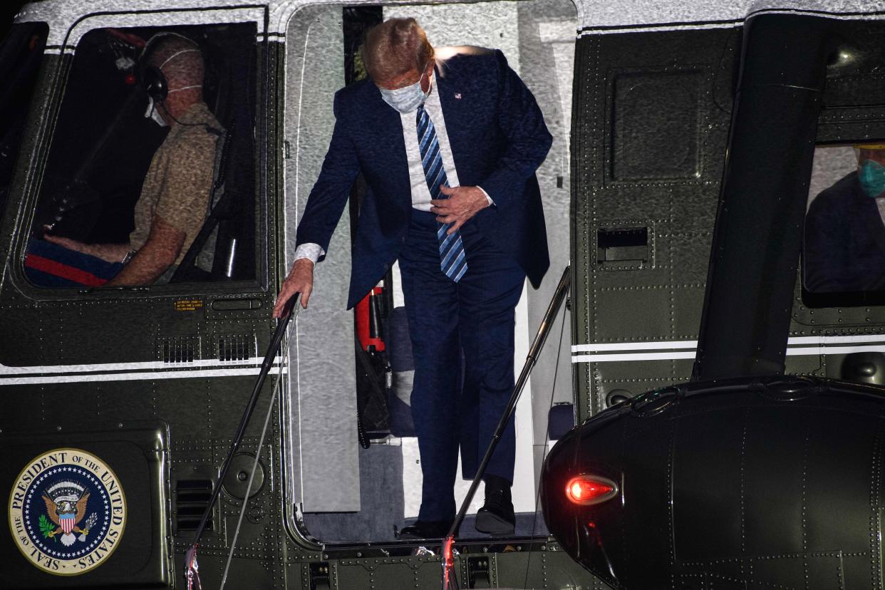 US President Donald Trump steps off Marine One wearing a facemask as he arrives at the White House upon his return from Walter Reed Medical Center, where he underwent treatment for Covid-19, in Washington, DC, on October 5, 2020. (Photo by NICHOLAS KAMM / AFP) (Photo by NICHOLAS KAMM/AFP via Getty Images)