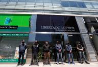 Police officers stand guard outside the building where Dr. Luque has his office in Buenos Aires