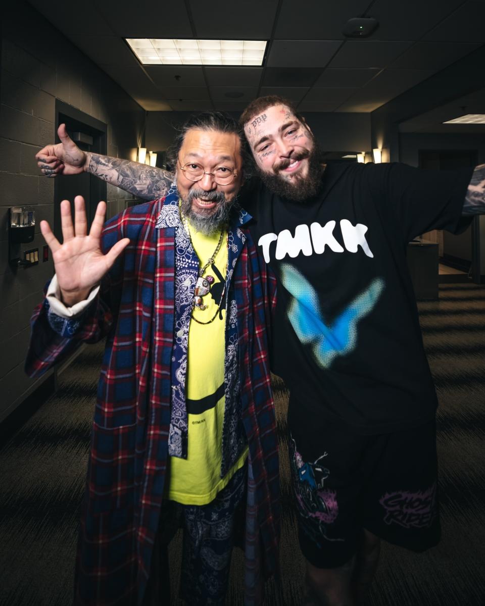 Japanese artist Takashi Murakami, left, and American rapper and singer Post Malone pose together for a photo when Murakami visits Malone during his tour at Crypto.com Arena in Los Angeles on Nov. 15, 2022. Murakami created various artworks and products, featured in a pop-up store in Los Angeles, during Malone’s tour for his latest album, "Twelve Carat Toothache." (RK @rkrkrk via AP)