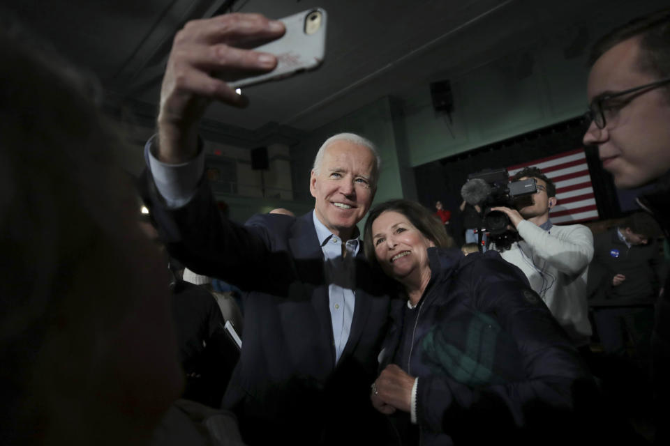 Democratic presidential candidate former Vice President Joe Biden smiles as he takes a selfie during a campaign stop in Exeter, N.H., Monday, Dec. 30, 2019. (AP Photo/Charles Krupa)