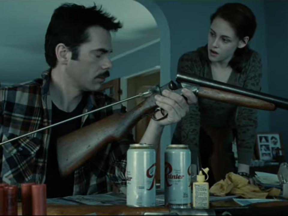 charlie cleaning his gun with beer cans on the table while talking to bella in twilight
