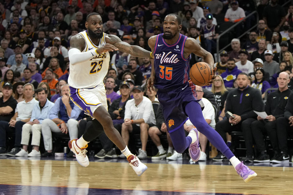 Phoenix Suns forward Kevin Durant (35) drives around Los Angeles Lakers forward LeBron James (23) during the second half of an NBA basketball game, Sunday, Feb. 25, 2024, in Phoenix. (AP Photo/Rick Scuteri)