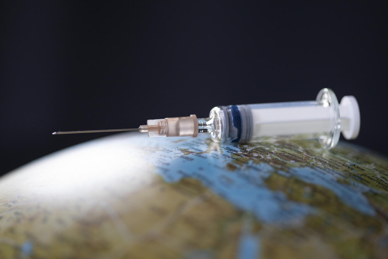 BONN, GERMANY - JUNE 29:  In this photo illustration a syringe with indefinite content is laying on a globe on June 29, 2020 in Bonn, Germany. (Photo by Ute Grabowsky/Photothek via Getty Images)
