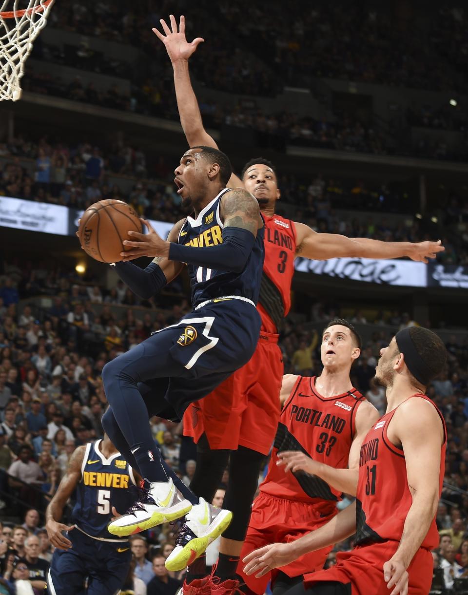 Denver Nuggets guard Monte Morris, front, drives to the rim past Portland Trail Blazers guard CJ McCollum, back left, forward Zach Collins and guard Seth Curry in the first half of Game 7 of an NBA basketball second-round playoff series Sunday, May 12, 2019, in Denver. (AP Photo/John Leyba)