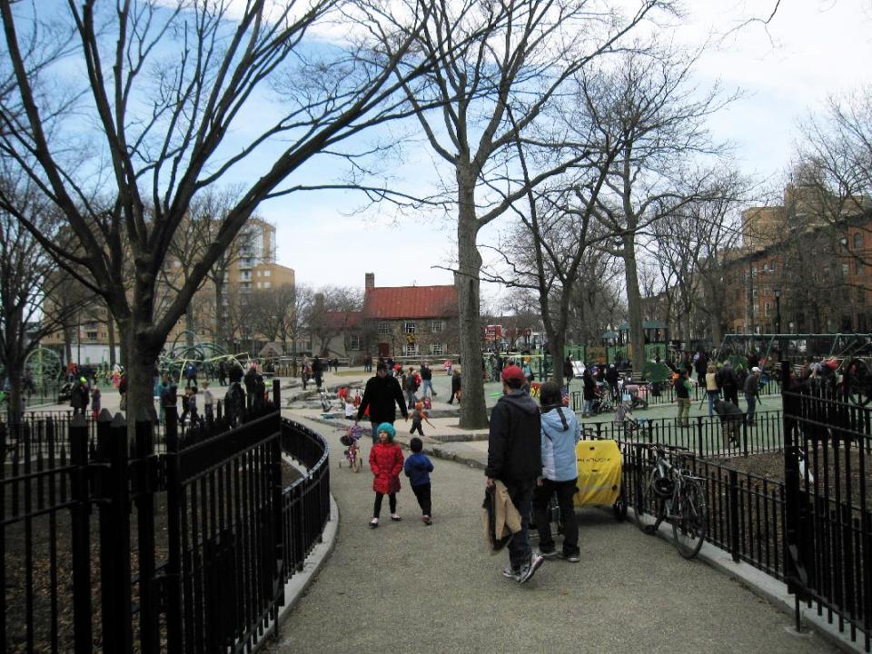 This April 7, 2013 image shows people in a playground at Washington Park in the Brooklyn borough of New York. A baseball park was located on the site beginning in the 1880s, and the team, later known as the Brooklyn Dodgers, used the Old Stone House, background center, as a clubhouse. A man named Charles Ebbets worked there as a ticket-taker, eventually took over the team, and later built the Dodgers’ storied ballpark at Ebbets Field. A new movie, “42,” tells the story of Brooklyn Dodger Jackie Robinson, who integrated Major League Baseball and played at Ebbets. (AP Photo/Beth J. Harpaz)
