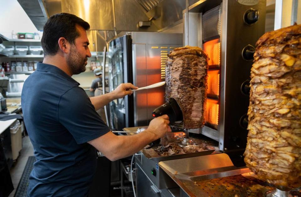 Owner Yusuf Topal shaves rotisserie lamb and beef in 2022 at Jayna Gyro in East Sacramento. The restaurant has a new location in Roseville. Paul Kitagaki Jr./pkitagaki@sacbee.com