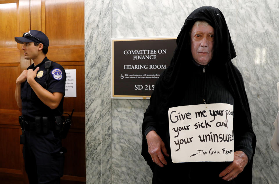 A protester dressed as the grim reaper stands outside the Senate Finance Committee hearing room Monday hours ahead a hearing on the latest effort to repeal Obamacare on Capitol Hill in Washington. (Photo: Kevin Lamarque / Reuters)