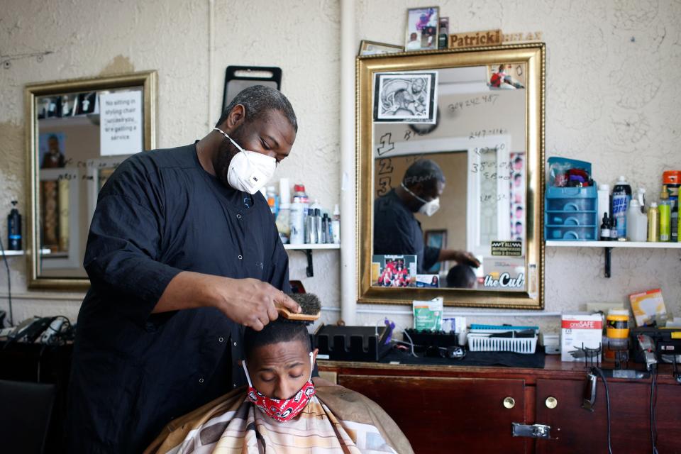 Barber Patrick Watkins of Jet Cuts & Styles finishes up a haircut on Darrell Stevens at the reopened barbershop in Athens, Georgia, on April 24.