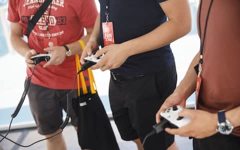 Attendees hold Microsoft Corp. Xbox One controllers while playing during a UbiSoft Entertainment SA event - Credit: Patrick T. Fallon&nbsp;/Bloomberg&nbsp;