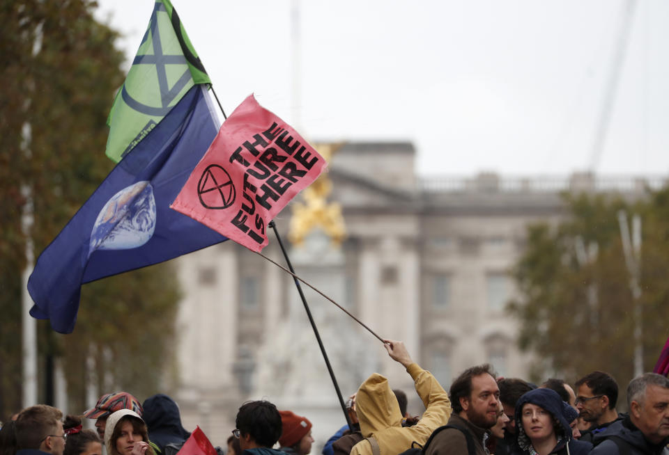 Climate protestors block the Mall leading to Buckingham Palace, rear, central London Monday, Oct. 7, 2019. Activists with the Extinction Rebellion movement blocked major roads in London, Berlin and Amsterdam on Monday at the beginning of what was billed as a wide-ranging series of protests demanding new climate policies. (AP Photo/Alastair Grant)