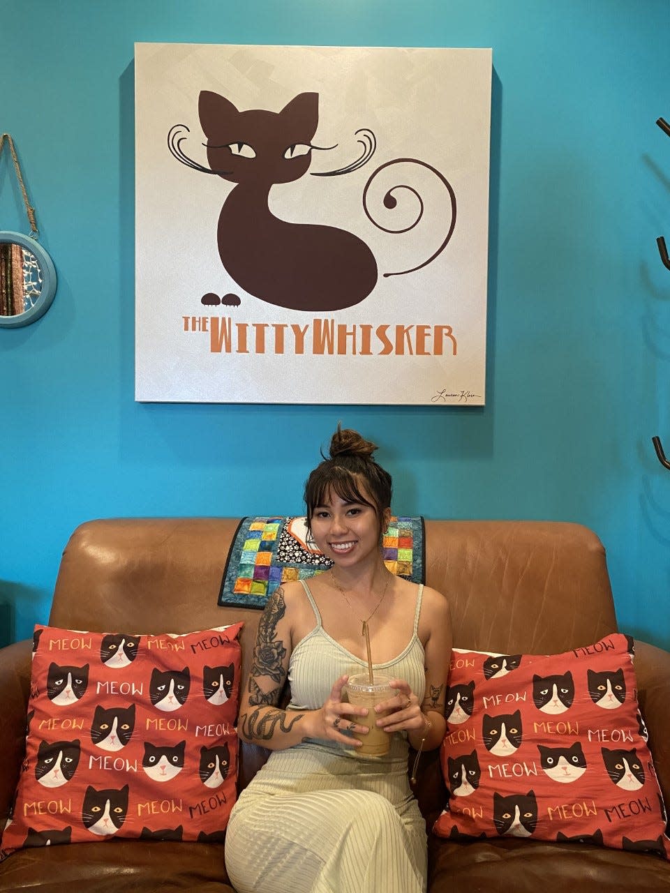 Salena Le poses at The Witty Whisker, a cat café in St. Augustine.