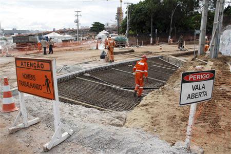 Workers work on areas of infrastructure near the construction site of the Arena das Dunas stadium, in Natal May 10, 2014. REUTERS/Nuno Guimaraes