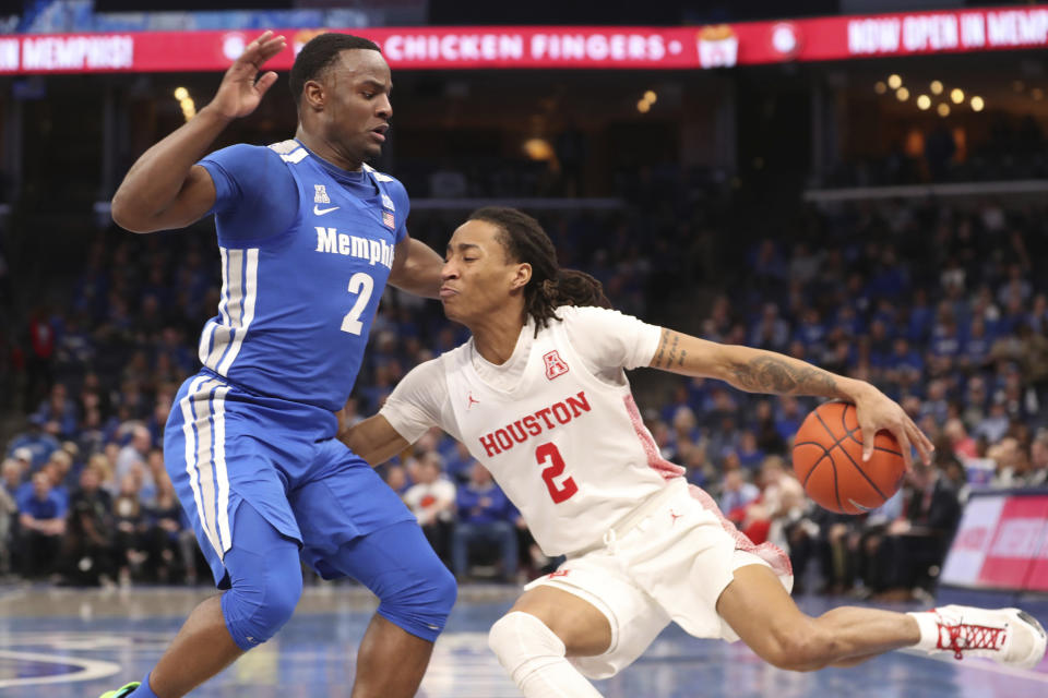 Houston guard Caleb Mills (2) drives the ball past Memphis guard Alex Lomax (2) in the first half of an NCAA college basketball game Saturday, Feb. 22, 2020, in Memphis, Tenn. (AP Photo/Karen Pulfer Focht)