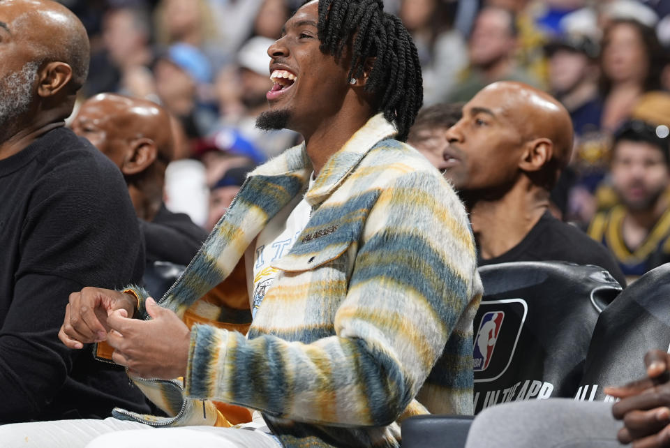 Philadelphia 76ers guard Tyrese Maxey, center, looks on from the bench in the first half of an NBA basketball game against the Denver Nuggets, Saturday, Jan. 27, 2024, in Denver. (AP Photo/David Zalubowski)