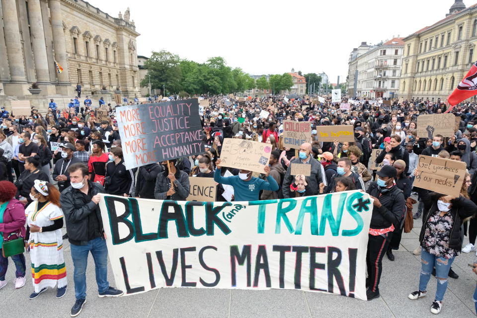 Teilnehmer einer Demonstration auf dem Simsonplatz protestieren mit einem Transparent, das den Slogan "Black and Trans Lives Matter" trägt. Foto: Sebastian Willnow / dpa-Zentralbild / dpa