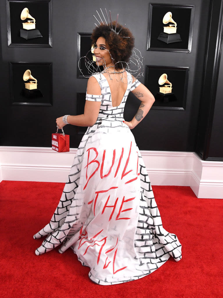 Joy's dress has bricks drawn on it, with "build the wall" in large letters on the back