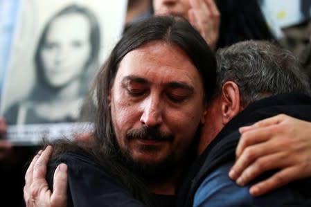 Javier Matias Darroux Mijalchuk, son of Elena Mijalchuk and Juan Manuel Darroux, who disappeared during Argentina's former 1976-1983 dictatorship, is comforted by his uncle, Roberto Mijalchuk during a news conference in Buenos Aires