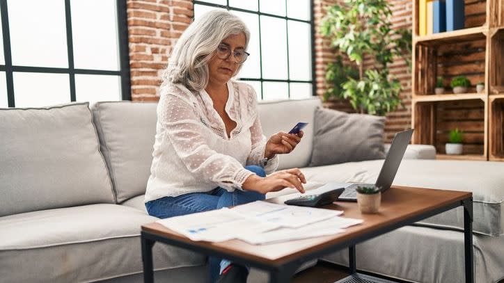 A woman calculates her tax liability from selling a piece of art. 