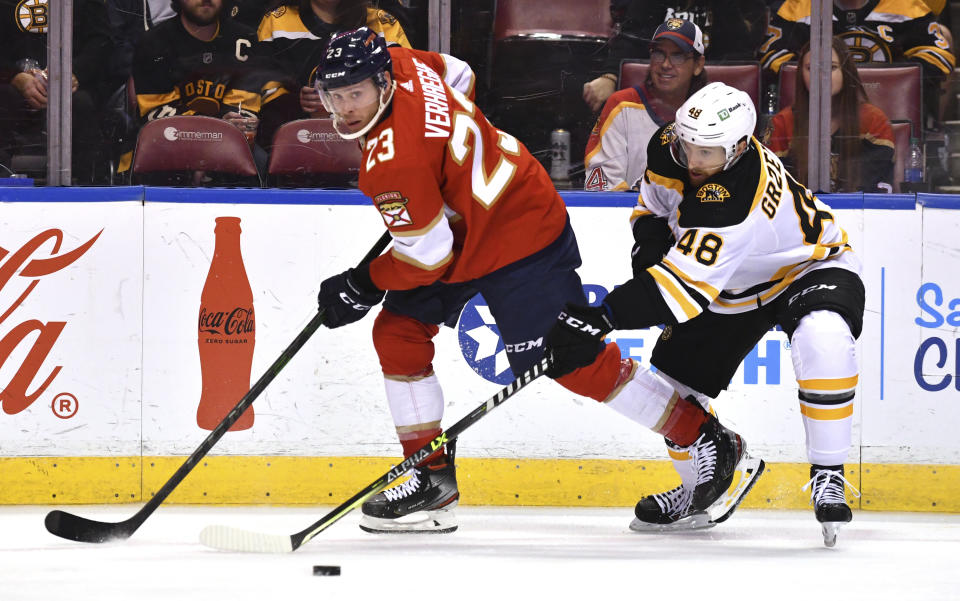 Florida Panthers left wing Carter Verhaeghe (23) and Boston Bruins defenseman Matt Grzelcyk (48) battle for possession during the second period of an NHL hockey game Wednesday, Oct. 27, 2021, in Sunrise, Fla. (AP Photo/Jim Rassol)