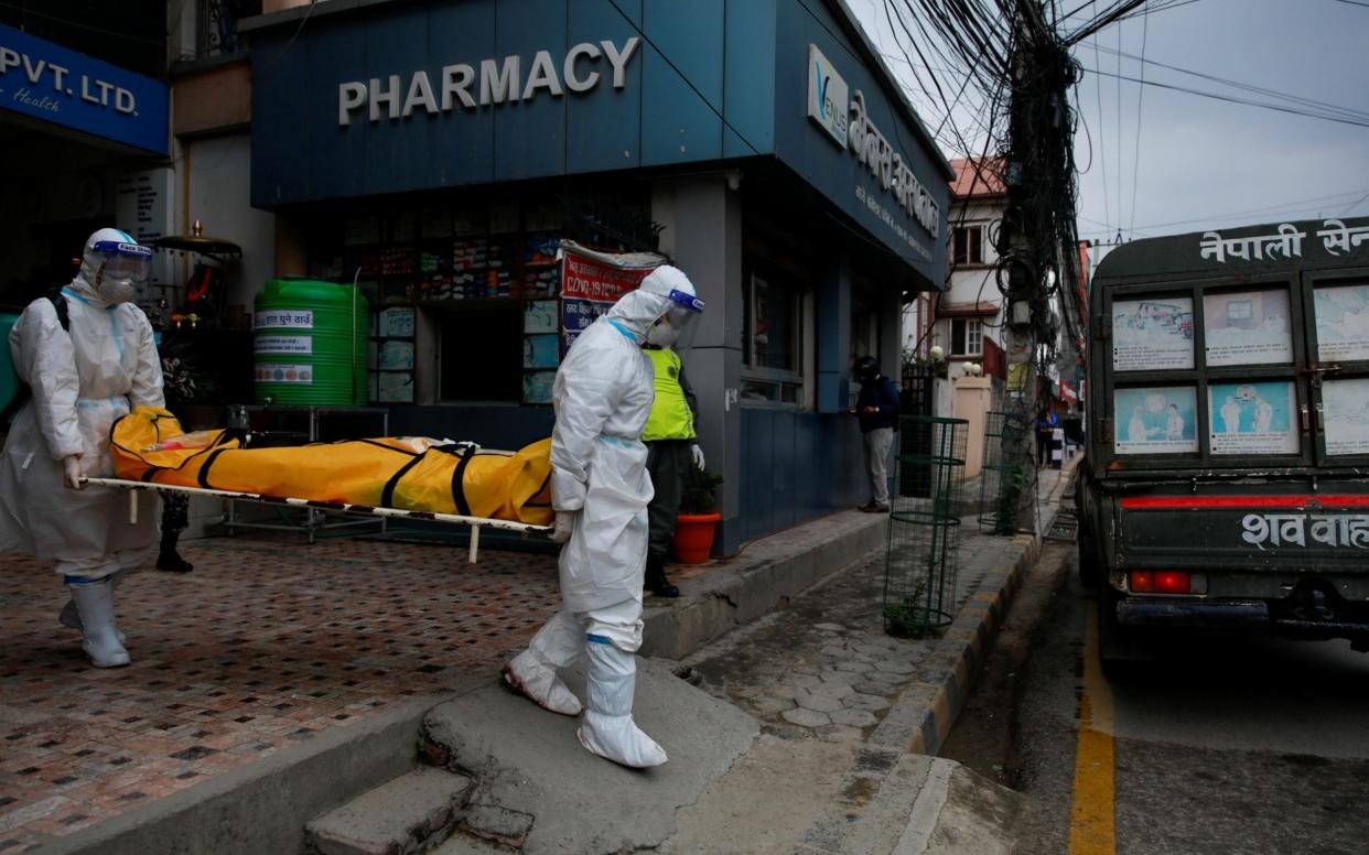 Members of Nepal army personnel wearing personal protective equipment (PPE) carry a body of a person who died from coronavirus disease (COVID-19)  - Navesh Chitrakar/Reuters