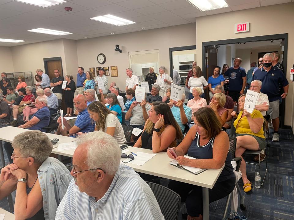 Town of Delafield residents hold up signs toward the developers hoping to build around 250 units on the 150-acre Thomas Farm property.