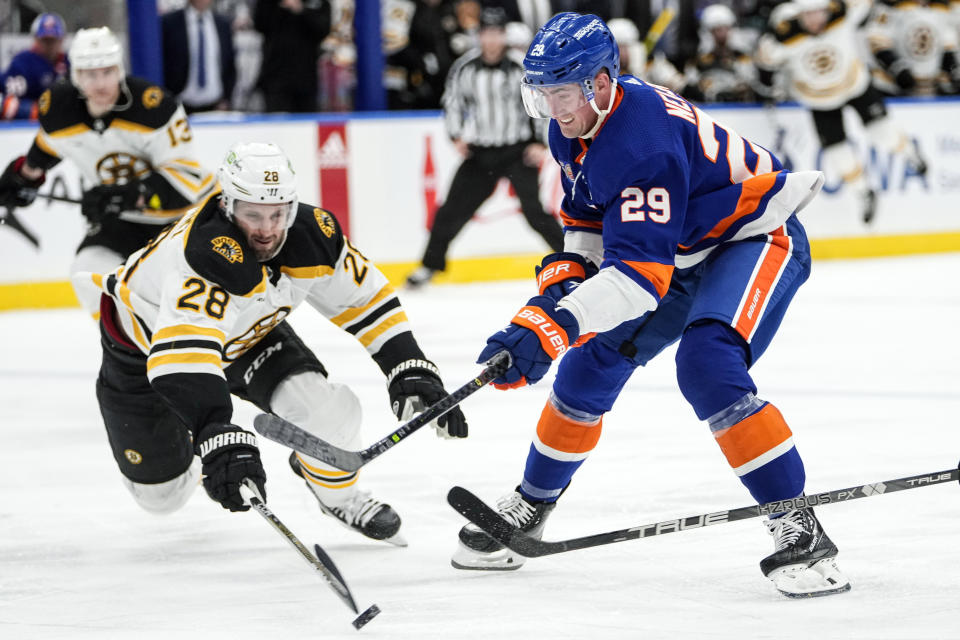 Boston Bruins' Derek Forbort (28) fights for control of the puck with New York Islanders' Brock Nelson (29) during the second period of an NHL hockey game Wednesday, Jan. 18, 2023, in Elmont, N.Y. (AP Photo/Frank Franklin II)