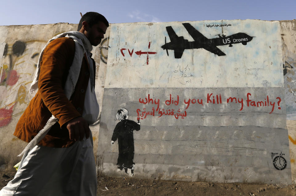 A man walks past graffiti denouncing U.S. drone strikes in Yemen. (Photo: Khaled Abdullah/Reuters)