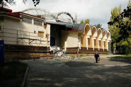 A child walks past a damaged building in the Oktyabrsky district of Donetsk, Ukraine, September 8, 2017. REUTERS/Alexander Ermochenko