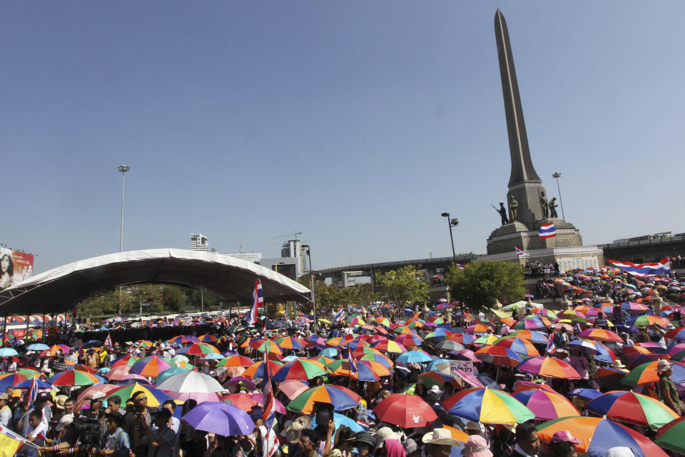 Anti-government protesters use umbrellas to block the strong sun as they occupy roads during a rally at the Victory Monument in Bangkok, Thailand Monday, Jan. 13, 2014. Anti-government protesters took over key intersections in Thailand's capital Monday, halting much of the traffic into Bangkok's central business district as part of a months-long campaign to thwart elections and overthrow the democratically elected prime minister. (AP Photo/Apichart Weerawong)