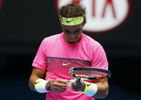 Rafael Nadal of Spain looks at the bandages on his hand after missing a shot to Tomas Berdych of the Czech Republic during their men's singles quarter-final match at the Australian Open 2015 tennis tournament in Melbourne January 27, 2015. REUTERS/Athit Perawongmetha