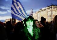 A woman holds a Greek flag as she takes part in an anti-austerity pro-government demonstration in front of the parliament in Athens February 11, 2015. REUTERS/Yannis Behrakis